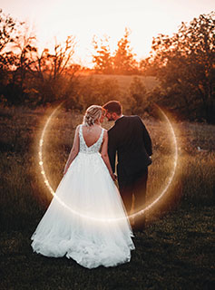 Bride and groom kissing at sunset